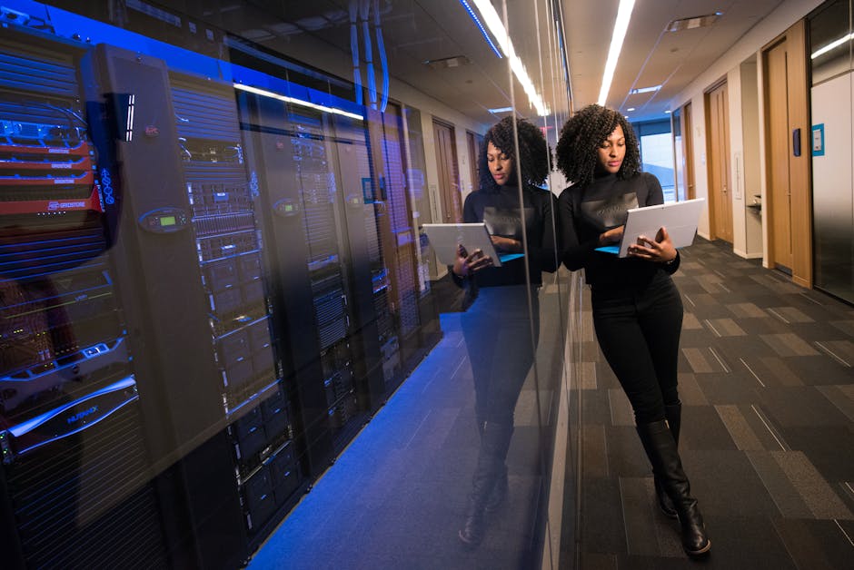Small business server rack and several edge devices displaying an AI operations dashboard on a wall-mounted monitor in an office