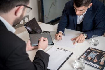 Business users in a meeting looking at a tablet displaying a no-code governance checklist and platform connector icons