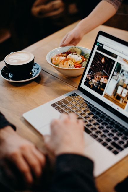 Small business owner checking website on laptop inside shop.