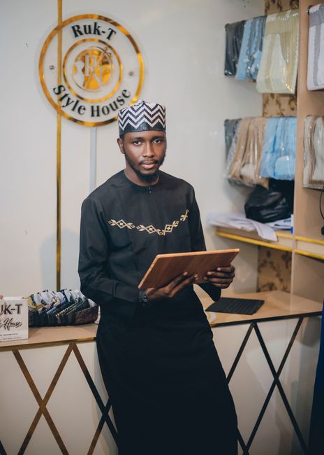 Local retail owner in a boutique holding a tablet to manage online orders and website analytics.