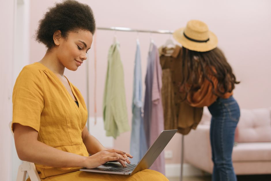 Small boutique owner using a laptop in her store to manage online orders and website lead capture.